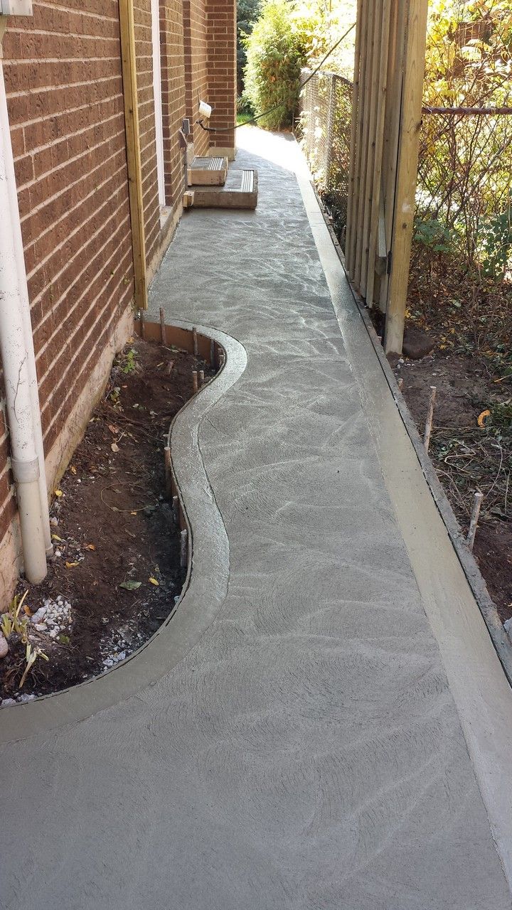 the walkway is made out of concrete and has been laid in front of a brick building