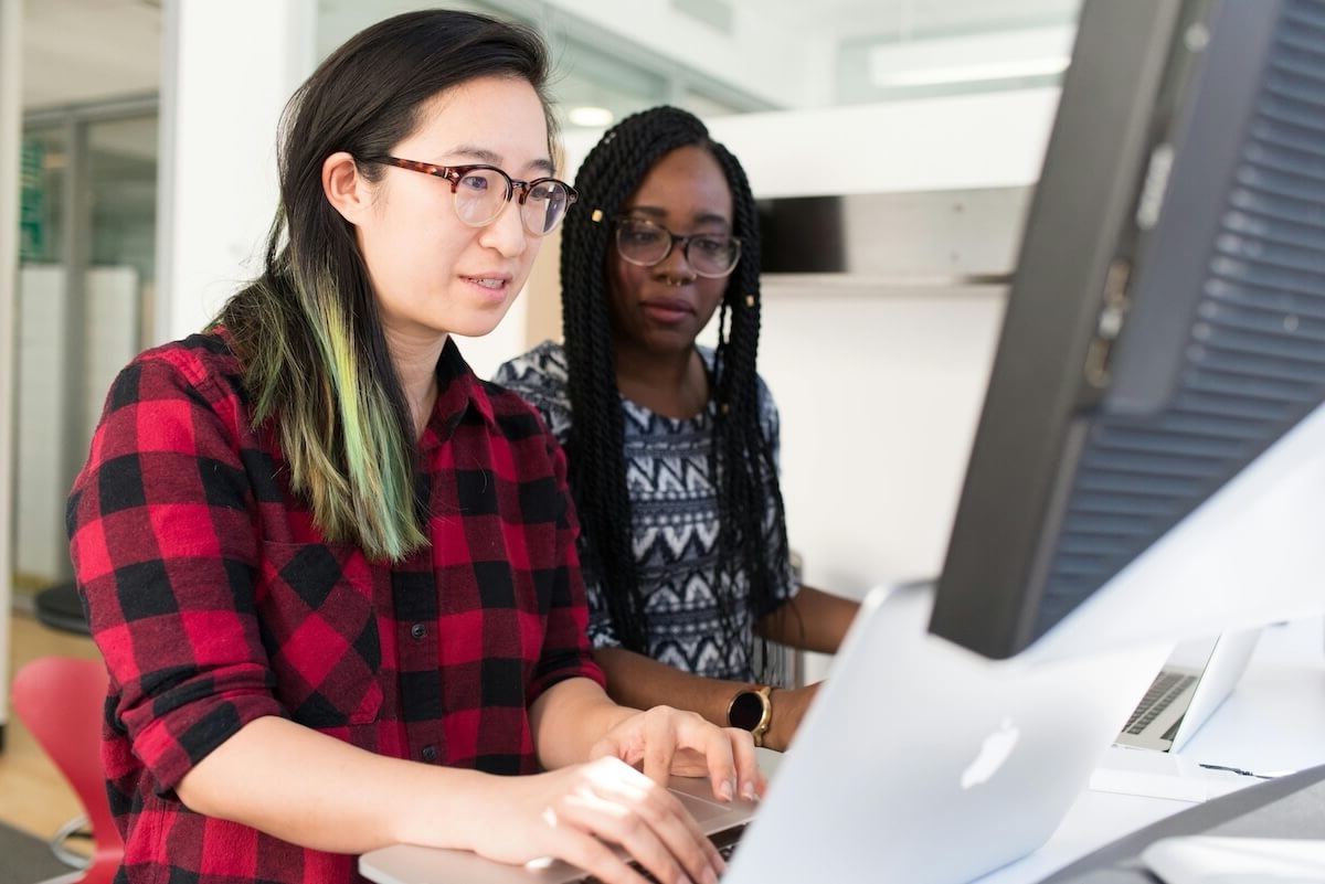 Woman Wearing Red and Black Checkered Blouse Using Macbook
