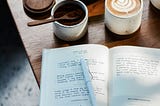 A journal and coffee with coffee beans on a vintage table