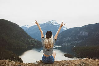 A photo of a young, carefree woman celebrating in nature