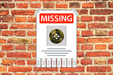 An image of a missing button poster on a red brick wall