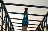 A person is holding a handstand on a bridge. Their form is good, with legs straight and feet together.