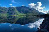 The mountains of Torridon are perfectly mirrors in the calm sea loch below.