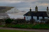 A weatherboarded cottage overlooks the white cliff’s of England’s south coast.