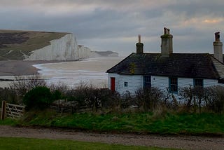 A weatherboarded cottage overlooks the white cliff’s of England’s south coast.