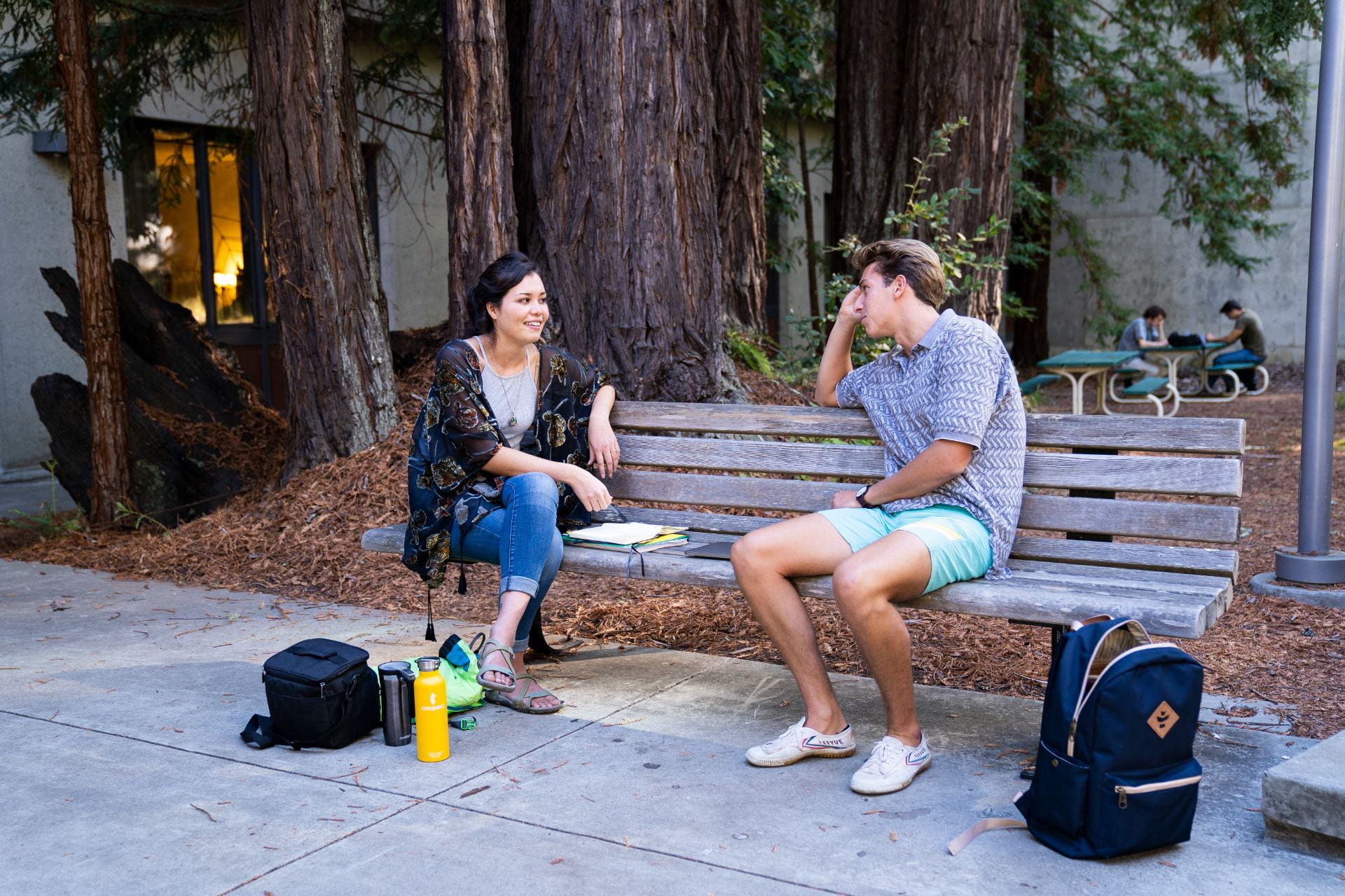 Two students sitting on a bench talking