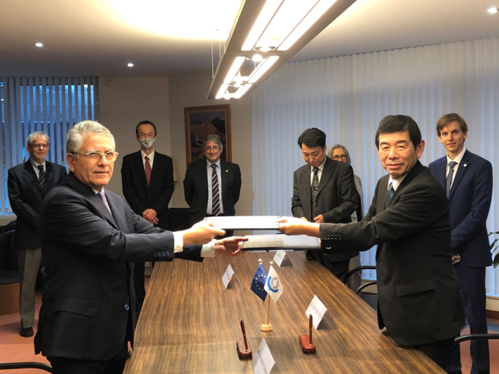 A group of people, including Mr Kunio MIKURIYA and Mr Gerassimos THOMAS, standing around a table.