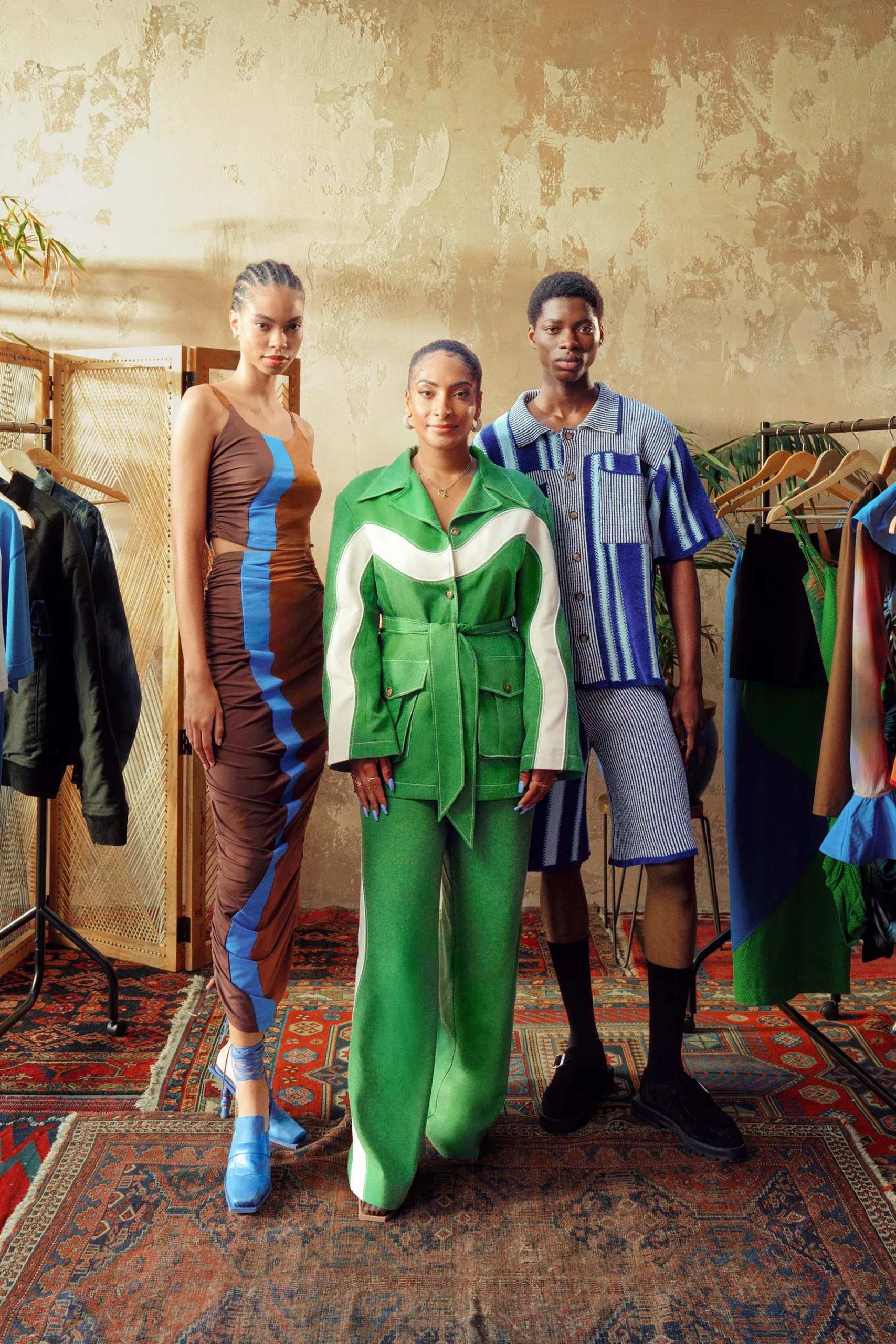 A group of people standing in front of racks of clothes.