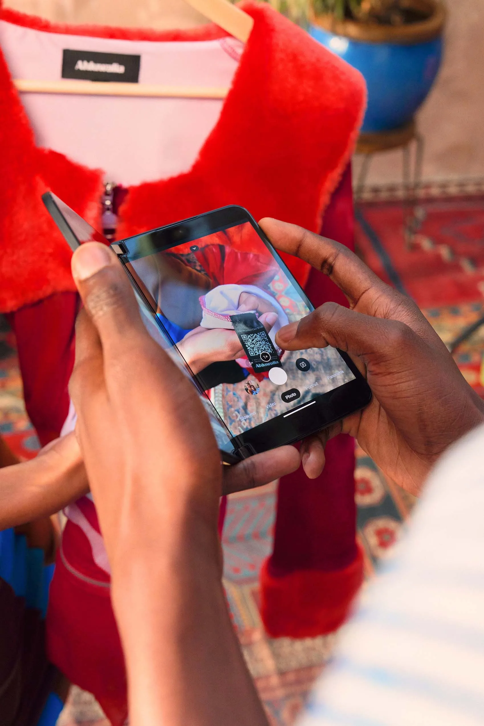 A person using a smartphone to take a picture of a mannequin.