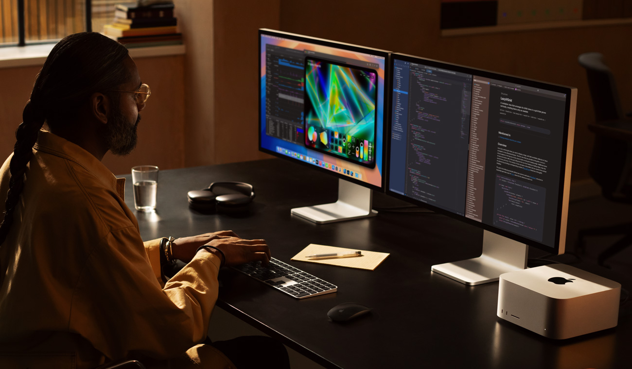 A professional working with Mac Studio and two Studio Display monitors