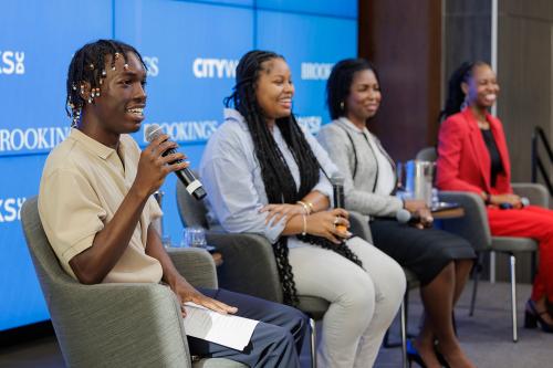 Four panelist seated on the stage at Brookings event, Youth perspectives on the future of apprenticeships, with microphones in hand and blue, Brookings backdrop