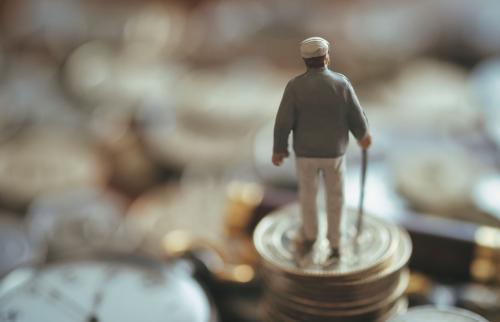 Figurine of an old man on a pile of coins.