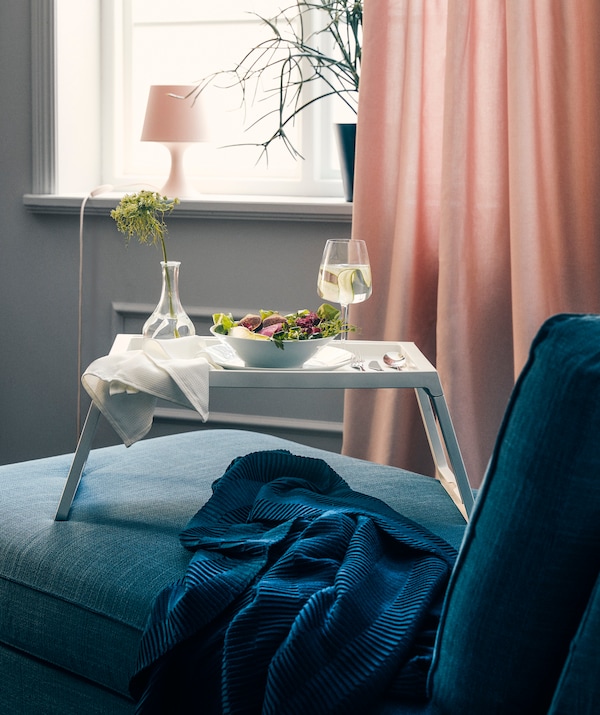 A white KLIPSK bed tray in the living room