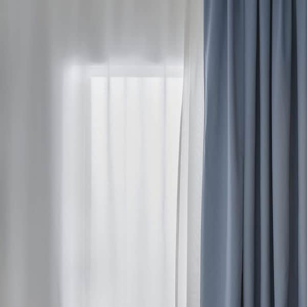 White sheer curtains and blue curtains layered on top.