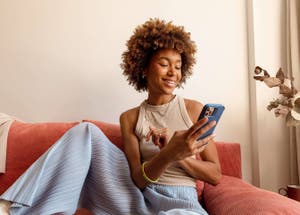 Woman holding a phone in her hand making a payment with Venmo.